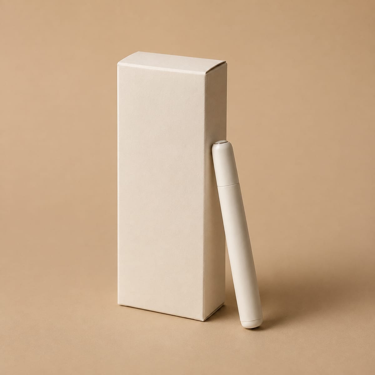 An unmarked ivory carton and capped pen-shaped device on a sand background; fictional concept packaging.